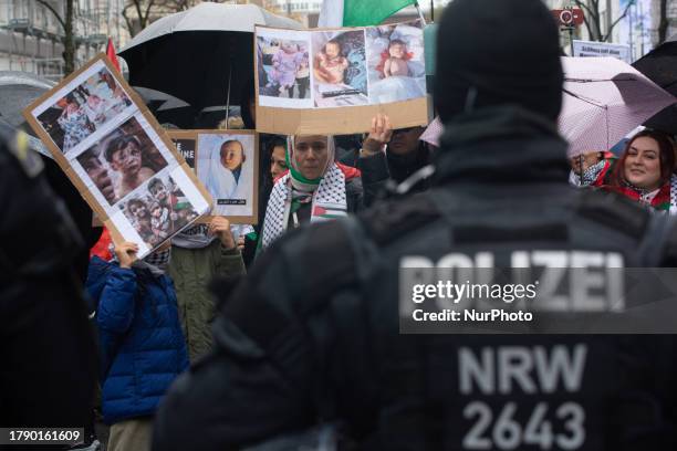 A protester holds signs of children of gaza before the pro-palestinian protest as hundreds of activists gather in front of Duesseldorf central...