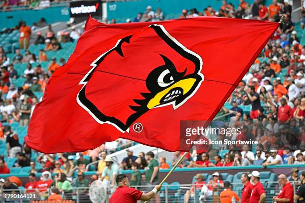 Louisville cheerleader waves a Cardinal flag after a Louisville touchdown in the fourth quarter as the Miami Hurricanes faced the Louisville...
