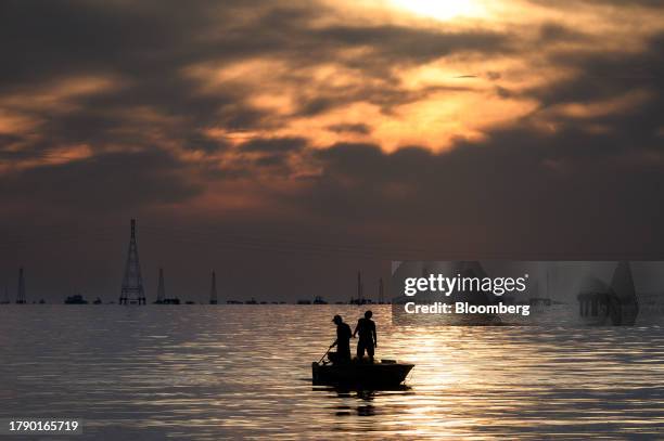 Fishermen in front of Petroleos de Venezuela SA oil rigs on lake Maracaibo in Cabimas, Zulia state, Venezuela, on Wednesday, Nov. 15, 2023....