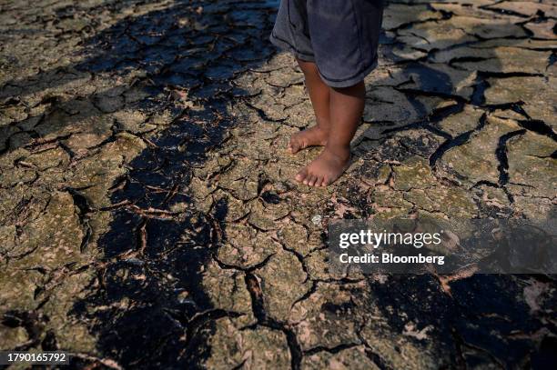 Resident walks over oil remnants on the shoreline of Lake Maracaibo in Cabimas, Zulia state, Venezuela, on Wednesday, Nov. 15, 2023. A decision by...