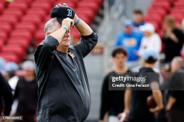 Bruins head coach Chip Kelly adjusts his hat while watching pregame warm ups before the game against the USC Trojans at Los Angeles Memorial Coliseum...