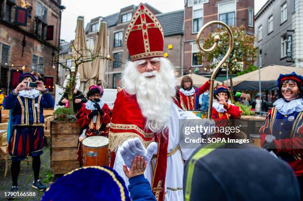 St. Nicholas is seen giving high five to the children waiting for him. The first Saturday after November 11th, the red-and-white-clad Sinterklaas...