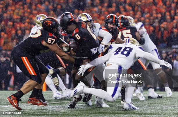 Quarterback Aidan Chiles of the Oregon State Beavers is sacked by defensive end Bralen Trice of the Washington Huskies during the first half at Reser...