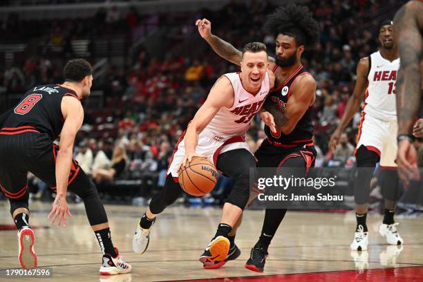 Duncan Robinson of the Miami Heat drives to the basket while being defended by Coby White of the Chicago Bulls in the first half on November 18, 2023...