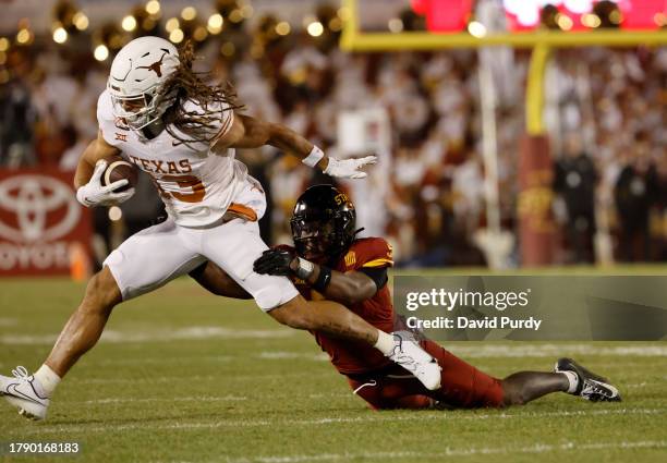 Wide receiver Jordan Whittington of the Texas Longhorns is tackled by defensive back Myles Purchase of the Iowa State Cyclones in the first half of...