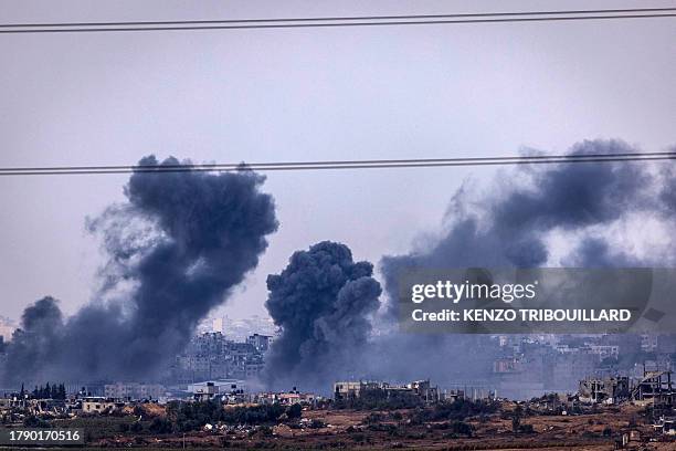 This picture taken from southern Israel shows smoke rising above buildings during an Israeli strike on the Gaza Strip on November 19 amid ongoing...