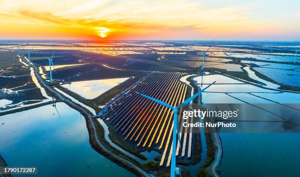 Wind turbine blades rotate in the tidal flat in Yancheng city, Jiangsu province, China, November 18, 2023.