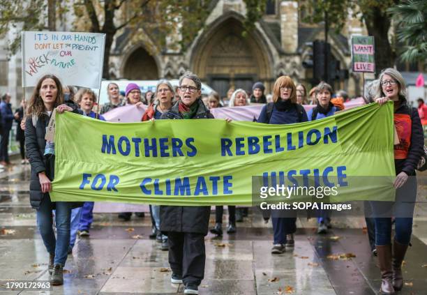 Protesters march behind a large banner saying ' Mothers Rebellion For Climate Justice'. Supporters of Extinction Rebellion Families meet to highlight...