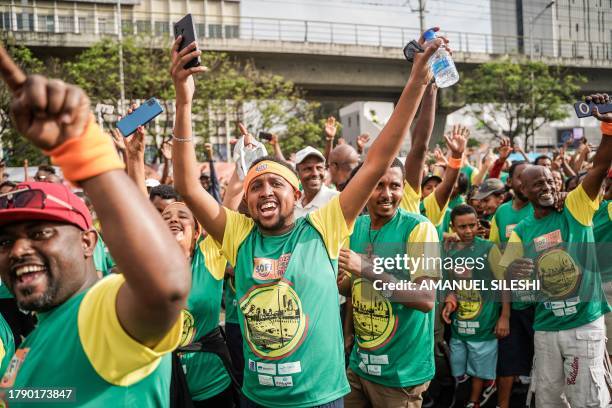 Runners wave and cheer during the 23rd edition of the Great Ethiopian Run at the Meskel Square in Addis Ababa on November 19, 2023. The Great...