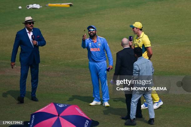 India's captain Rohit Sharma tosses the coin as his Australian counterpart Pat Cummins watches before the start the 2023 ICC Men's Cricket World Cup...