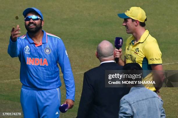 India's captain Rohit Sharma tosses the coin as his Australian counterpart Pat Cummins watches before the start the 2023 ICC Men's Cricket World Cup...