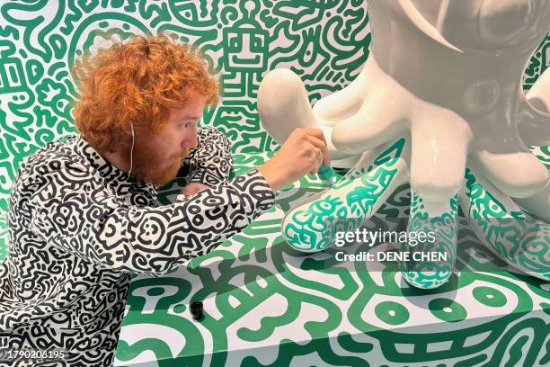 This photo taken on November 16, 2023 shows British artist Sam Cox, better known as Mr. Doodle, working on a sculpture named "Jellyboggle" at Pearl...