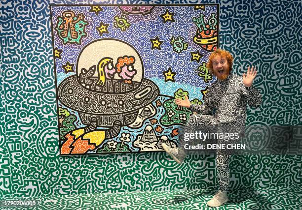 This photo taken on November 16, 2023 shows British artist Sam Cox, better known as Mr. Doodle, posing for a picture with his piece "The Doodles...