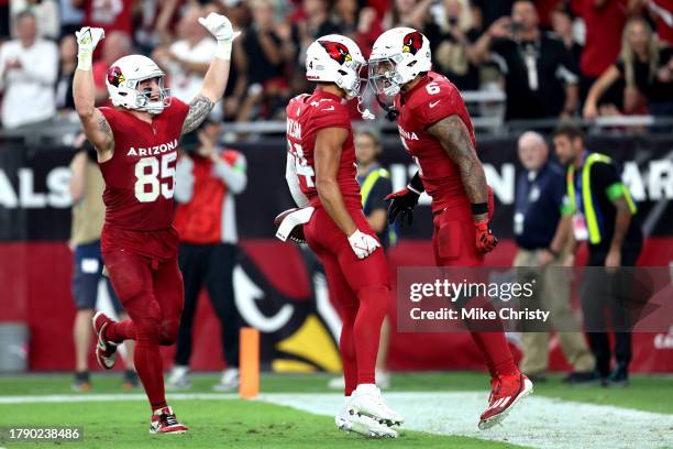 Trey McBride, Michael Wilson and James Conner of the Arizona Cardinals celebrate after a play during the second half in the game against the Atlanta...