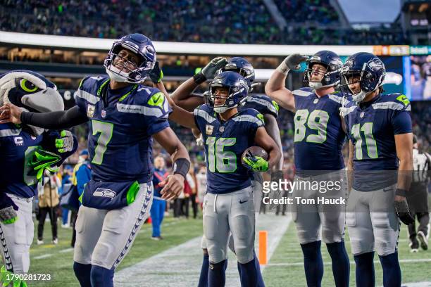 Geno Smith of the Seattle Seahawks celebrates with teammates after a receiving touchdown by Tyler Lockett of the Seattle Seahawks during the fourth...