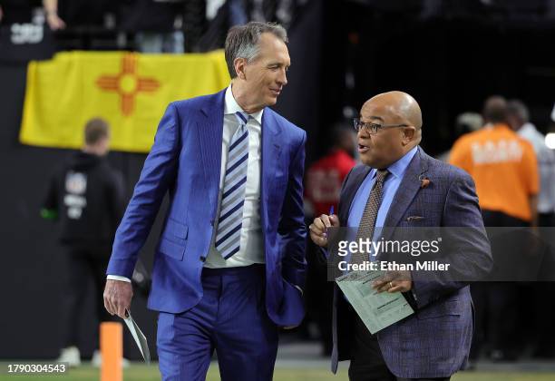 Sunday Night Football color commentator Cris Collinsworth and play-by-play announcer Mike Tirico walk onto the field before a game between the New...