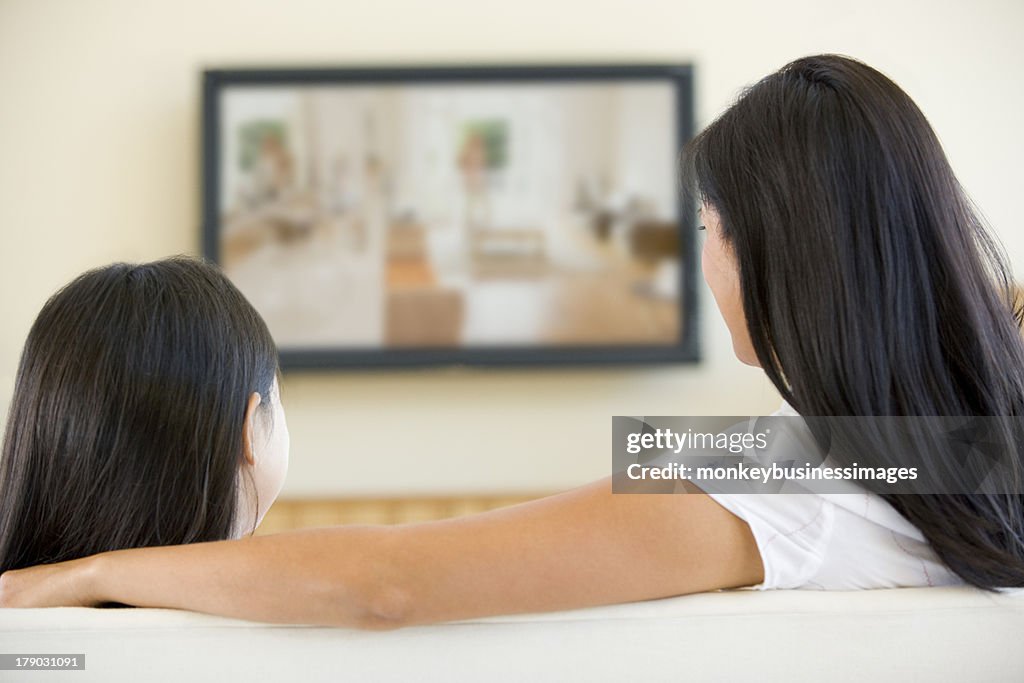 Woman and young girl in living room with television