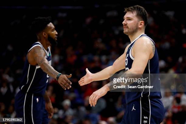 Luka Doncic of the Dallas Mavericks reacts with Derrick Jones Jr. #55 of the Dallas Mavericks after scoring during the third quarter against the New...