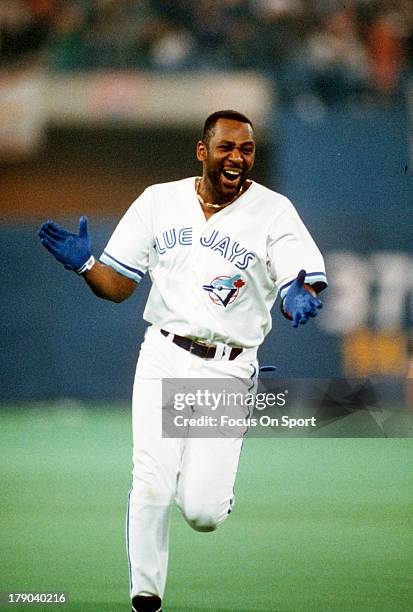 Joe Carter of the Toronto Blue Jays trots around the bases with jubilation after hitting a game winning and World Series winning three-run home run...