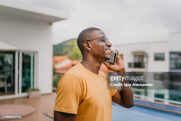 smiling man talking on smartphone at home - granny glasses stockfoto's en -beelden