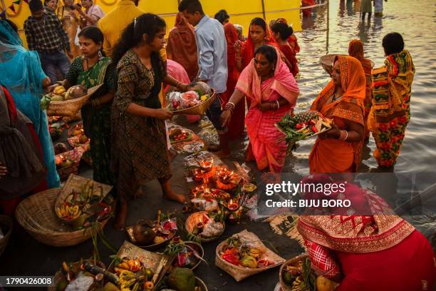 Devotees gather to worship the sun God on the banks of river Brahmaputra during the Hindu festival of 'Chhath Puja' in Guwahati on November 19, 2023.