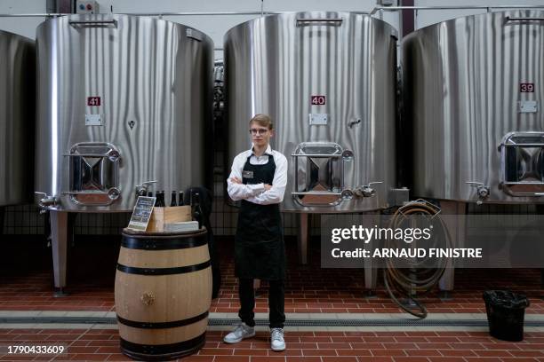 An employee waits in front of a wine barrel in the "Nouvelle cuverie" to serve to professionals for tasting the wine that will be sold during the...