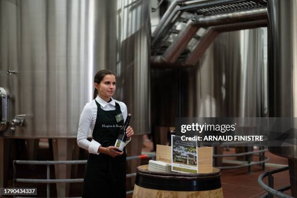 An employee waits in front of a wine barrel in the "Nouvelle cuverie" to serve to professionals for tasting the wine that will be sold during the...