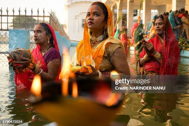 Hindu devotees offer prayers to Sun God, on 'Chhath Puja' at Durgiana temple in Amritsar on November 19, 2023.