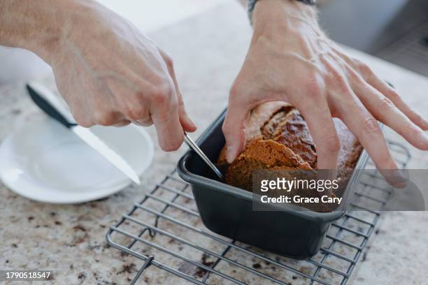 man cuts a slice of pumpkin bread - forma de bolo imagens e fotografias de stock