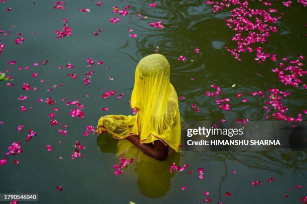 Hindu devotee takes part in a ritual to worship the sun god during 'Chhath puja' in Ajmer on November 19, 2023.
