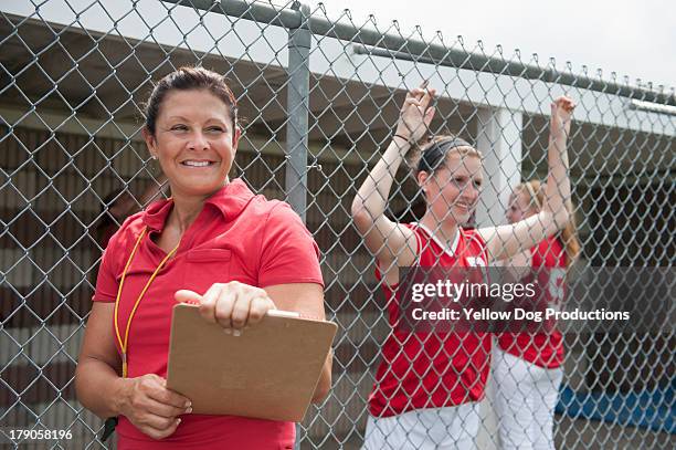 coach with  softball players on sidelines - softball sport stock pictures, royalty-free photos & images