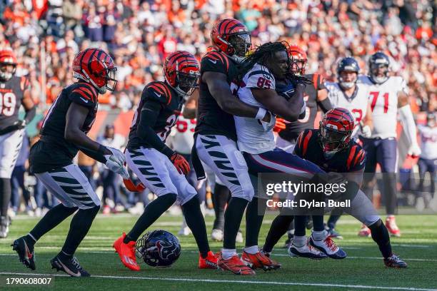 Noah Brown of the Houston Texans loses his helmet while being tackled by Germaine Pratt and Chidobe Awuzie of the Cincinnati Bengals in the second...