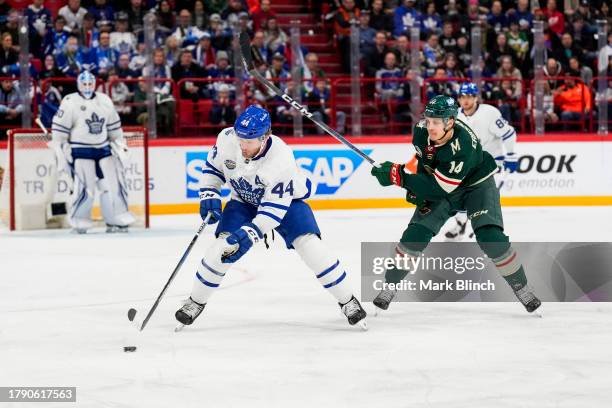 Morgan Rielly of the Toronto Maple Leafs plays the puck against Joel Eriksson Ek of the Minnesota Wild during the first period during the 2023 NHL...