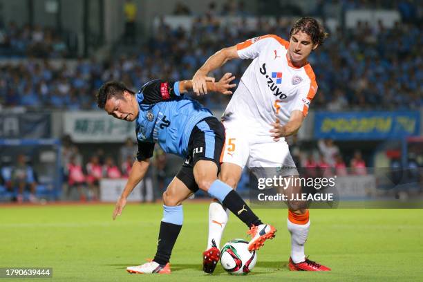 Yusuke Tasaka of Kawasaki Frontale controls the ball against Dejan Jakovic of Shimizu S-Pulse during the J.League J1 second stage match between...