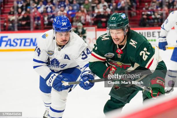 Auston Matthews of the Toronto Maple Leafs battles against Brandon Duhaime of the Minnesota Wild during the first period during the 2023 NHL Global...