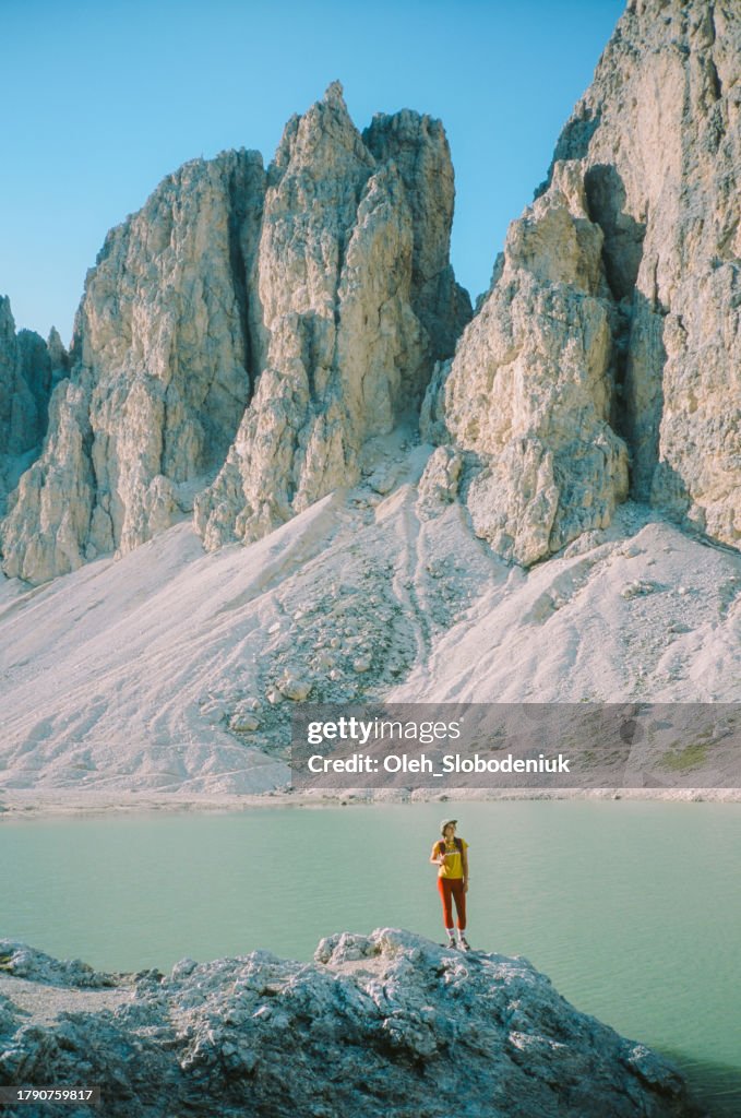 Woman hiking near lake Antermoia in Dolomites