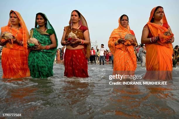 Hindu devotees offer prayers to the sun god during The Chhath Festival at the Juhu beach in Mumbai on November 19, 2023.