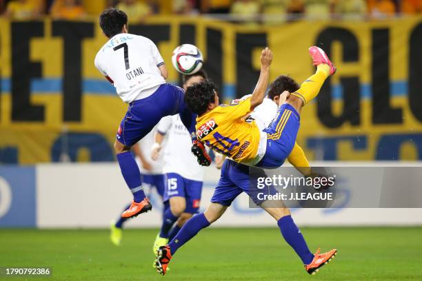Jun Kanakubo of Vegalta Sendai attempts an overhead kick while Hidekazu Otani and Ryoichi Kurisawa of Kashiwa Reysol attempt to block during the...