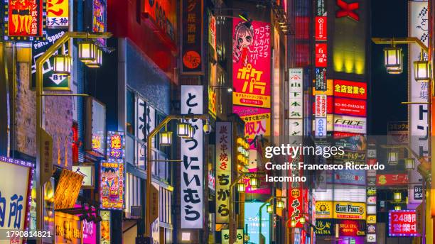 illuminated neon signs in shinjuku, tokyo, japan - quartiere a luci rosse foto e immagini stock