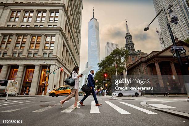 business people crossing fulton street in lower manhattan - young business person stock pictures, royalty-free photos & images