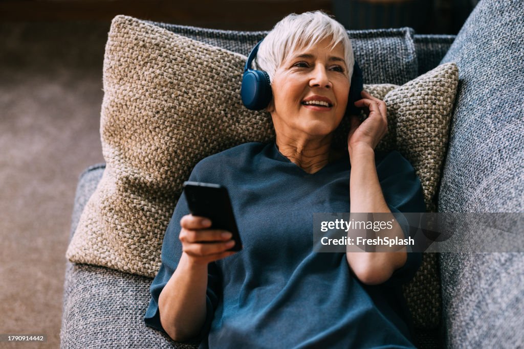 Sonic Tranquility: Senior Woman Listening to Music with Phone and Headphones