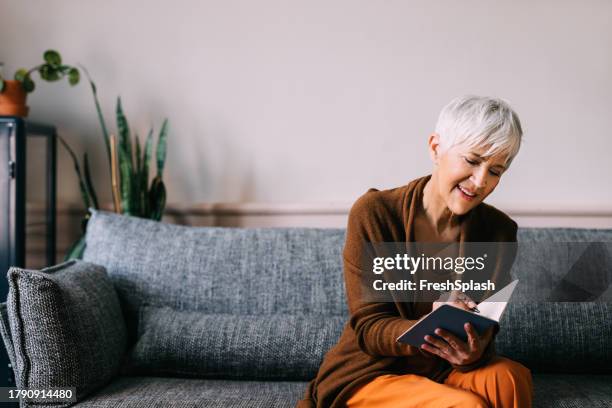 ink and imagination: senior woman lost in reading and writing - old diary stock pictures, royalty-free photos & images