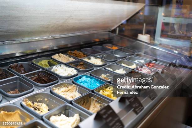 counter with various multi colored ice creams at a shop - ice cream counter stock-fotos und bilder