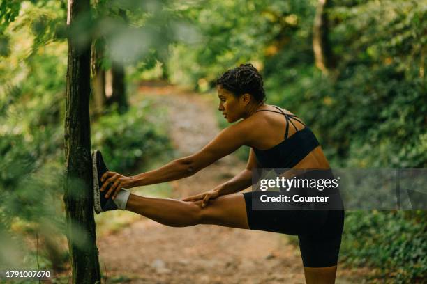 woman stretching after run in forest - warm up exercise stock pictures, royalty-free photos & images