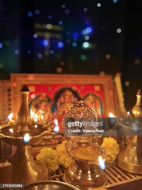 lit brass oil lamps/gajalakshmi vilakku against colorful bokeh/diwali/deepavali festival - laxmi ganesh stock pictures, royalty-free photos & images