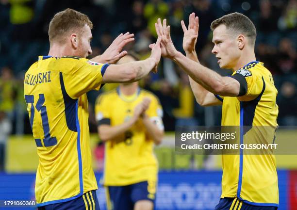 Sweden's midfielder Viktor Claesson celebrates scoring the opening goal with his teammate Sweden's forward Dejan Kulusevski during the UEFA Euro 2024...