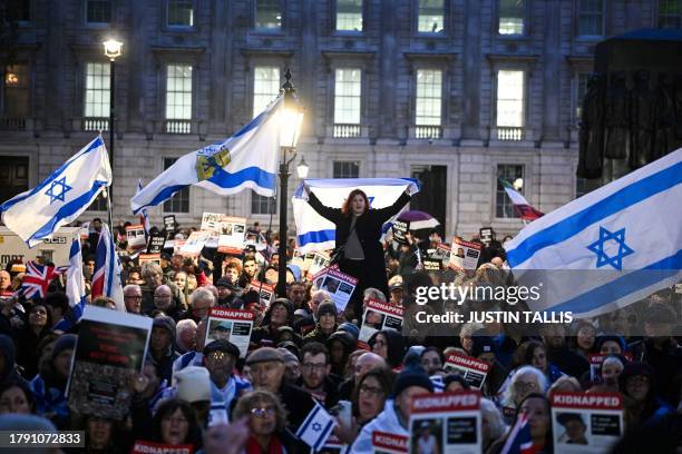 Protesters wave Israeli flags and hold photos of people held hostage by Palestinian militant group Hamas in Gaza, during a demonstration outside...