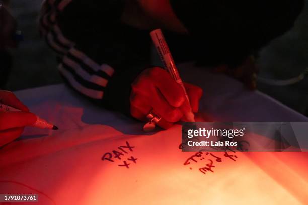 Demonstrators write peaceful messages during the peaceful demonstration organised by the organisation Solidarité Judéo-Arabe to demand peace...