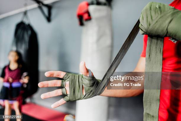 close-up of a man putting elastic bandage on hands at boxe gym - ace bandage stock pictures, royalty-free photos & images