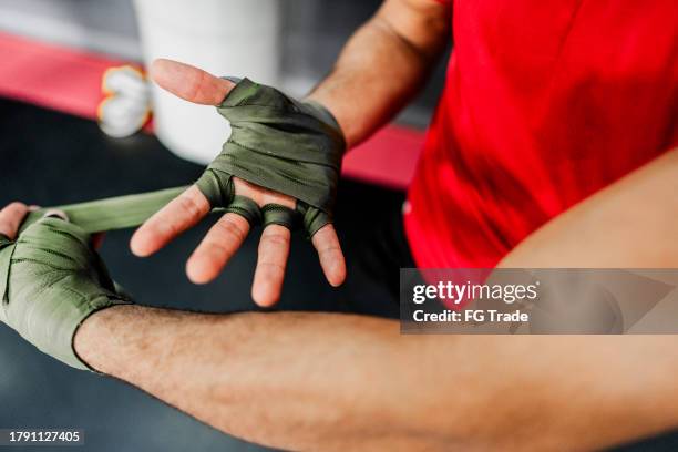 close-up of a man putting elastic bandage on hands at boxe gym - ace bandage stock pictures, royalty-free photos & images